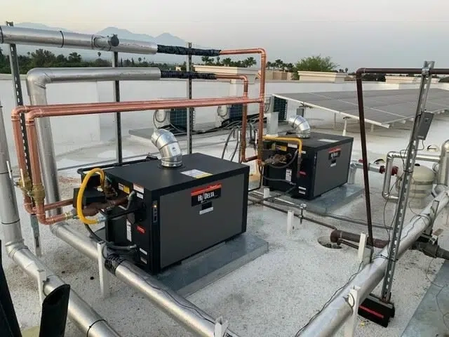 Two boilers installed on the rooftop of an apartment complex, photographed after the installation.